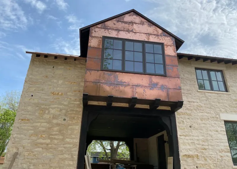 Copper metal panel facade on a stone building for Roof Repair in Melissa